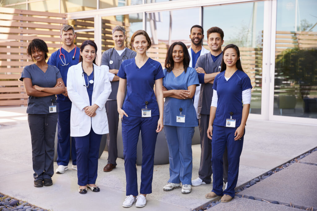 Healthcare team with ID badges stand outdoor