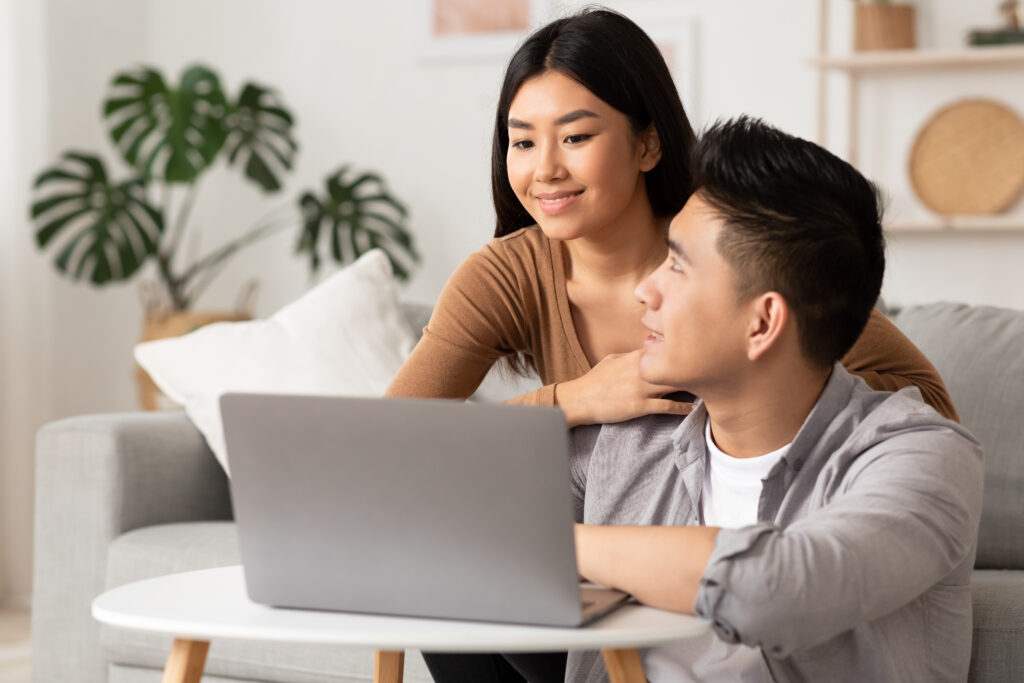 Filipino couple looking with laptop at home