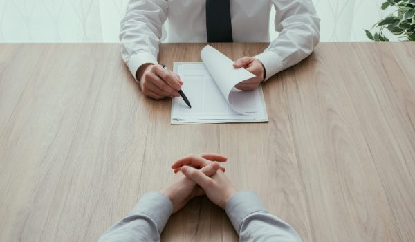 Examiner reading a resume during a job interview, employment and recruitment concept, point of view shot