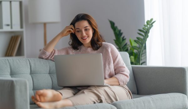 Happy casual beautiful woman using laptop at home.