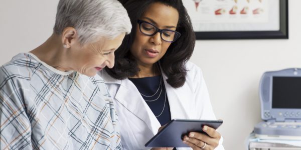 Female Doctor Explaining Report To Patient In Clinic