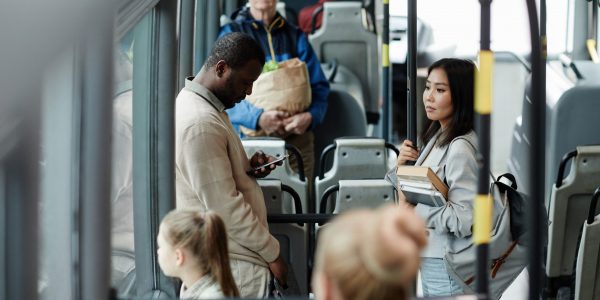 High angle view at young female student holding book on bus while traveling by public transport in city, copy space