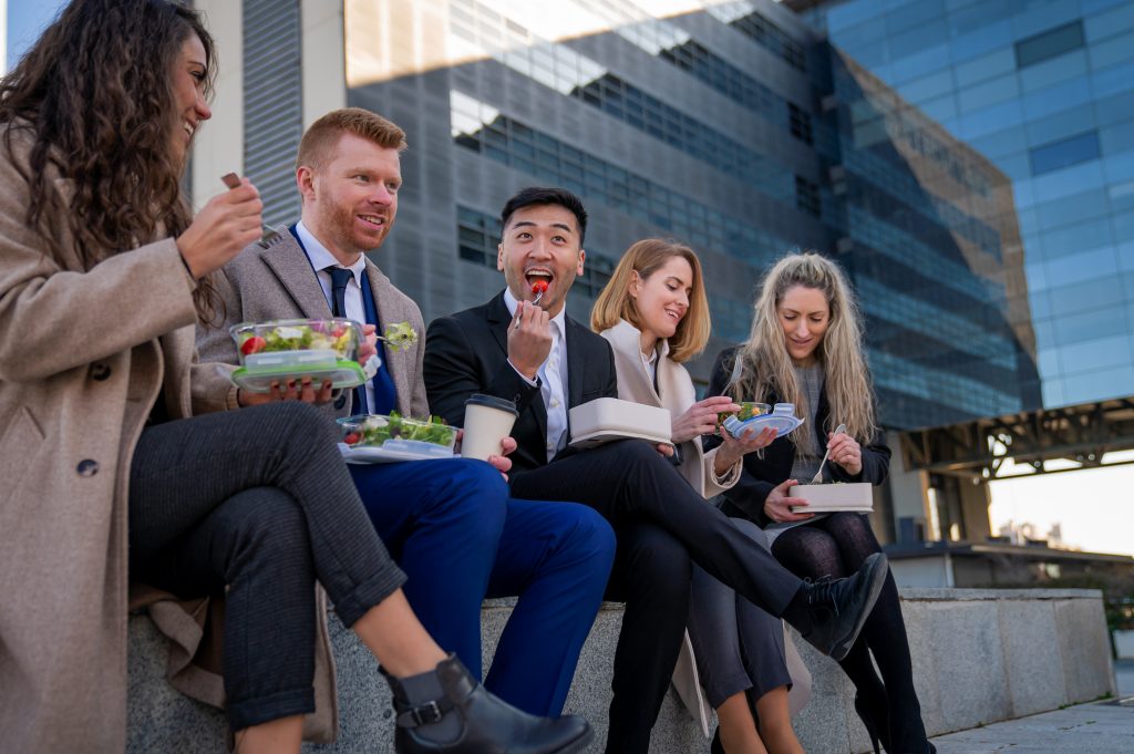 diverse employees eating lunch outside during their break